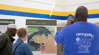 A group of residents looking at large informational posters about Latta.